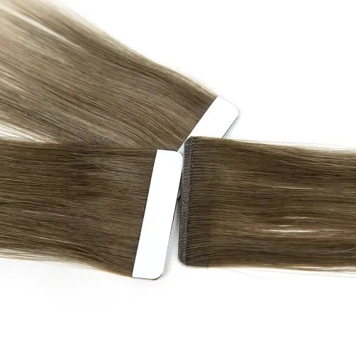 Invisible Genius Tape-In attachment tabs with white backing and hair placement visible